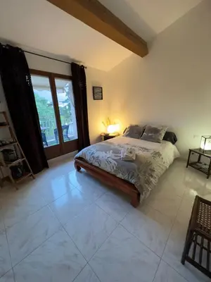 a bedroom with a bed and a large window at Chambre privée avec salle d’eau et terrasse au calme in Le Cannet