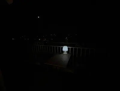 a white lamp sitting on a balcony at night at Chambre privée avec salle d’eau et terrasse au calme in Le Cannet