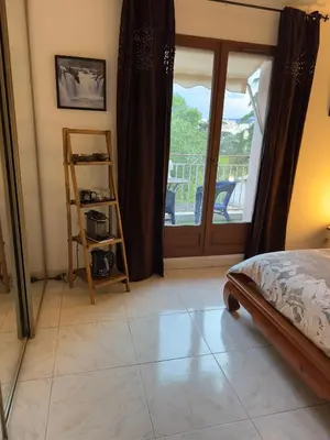 a bedroom with a bed and a view of a balcony at Chambre privée avec salle d’eau et terrasse au calme in Le Cannet