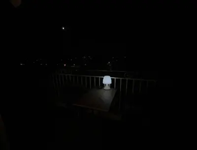 a white lamp sitting on a balcony at night at Chambre privée avec salle d’eau et terrasse au calme in Le Cannet