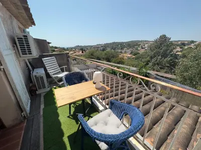 a balcony with a wooden table and chairs on it at Chambre privée avec salle d’eau et terrasse au calme in Le Cannet