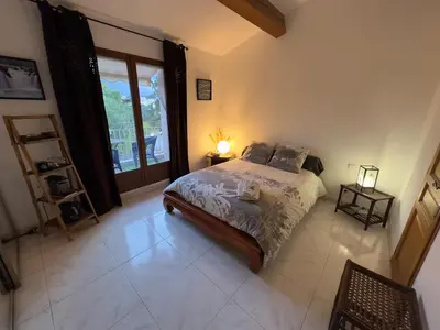 a bedroom with a bed and a large window at Chambre privée avec salle d’eau et terrasse au calme in Le Cannet