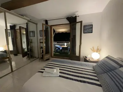 a bedroom with a large bed and a balcony at Chambre privée avec salle d’eau et terrasse au calme in Le Cannet