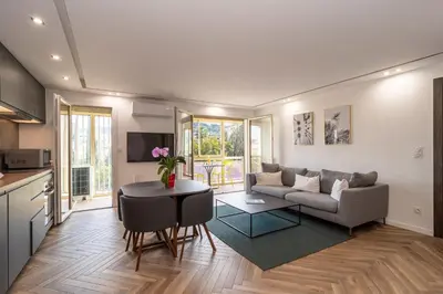 a living room with a couch and a table at Heart of Cannes contemporary 2BR garden view Palais & Croisette 5 mn by Olam Properties in Cannes