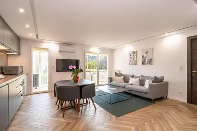 a living room with a couch and a table at Heart of Cannes contemporary 2BR garden view Palais & Croisette 5 mn by Olam Properties in Cannes