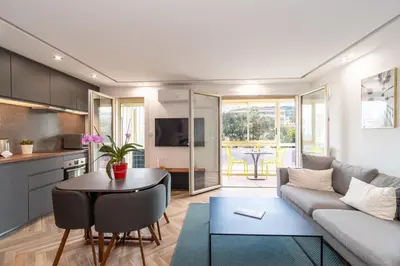a living room with a couch and a table at Heart of Cannes contemporary 2BR garden view Palais & Croisette 5 mn by Olam Properties in Cannes