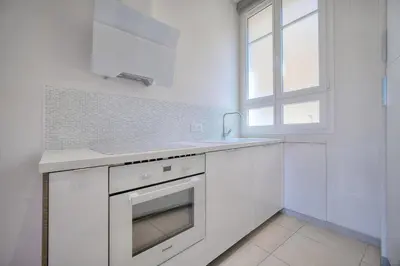 a white kitchen with a sink and a window at IMMOGROOM - Palais des festivals within walking distance - balcony - wifi - in Cannes