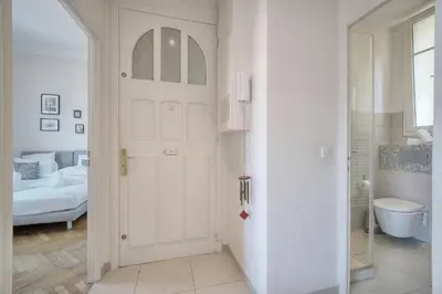a white door in a white room with a bed at IMMOGROOM - Palais des festivals within walking distance - balcony - wifi - in Cannes