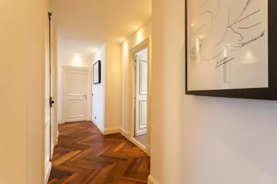 a hallway with wood floors and a picture on the wall at croisette appartement 3 chambres The Six in Cannes