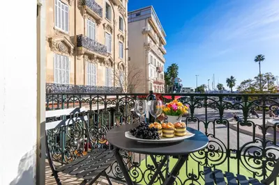 a table with a plate of food on a balcony at croisette appartement 3 chambres The Six in Cannes