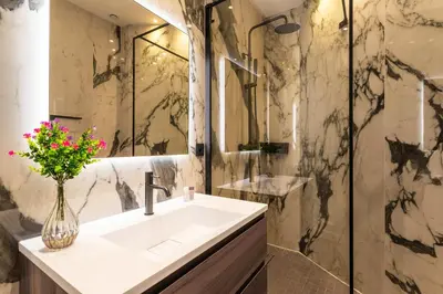 a bathroom with a sink and a vase of flowers at croisette appartement 3 chambres The Six in Cannes