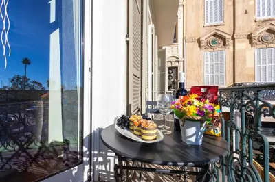 a table with food and flowers on a balcony at croisette appartement 3 chambres The Six in Cannes
