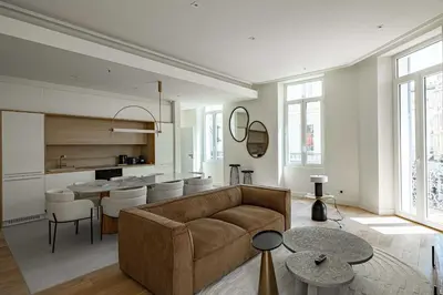 a living room with a couch and a kitchen at Superbe appartement 120m2 au coeur de Cannes in Cannes