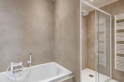 a bathroom with a tub and a glass shower at Superbe appartement 120m2 au coeur de Cannes in Cannes