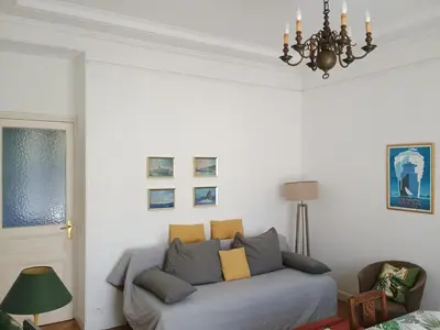 a living room with a couch and a chandelier at Cannes Holidays - Charmant, authentique, 3 Chambres, calme, Palais & Plage in Cannes