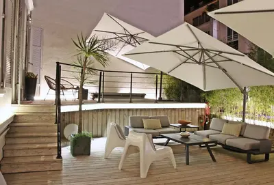 a patio with chairs and tables and umbrellas at Super Central, Spacious, Sunny Large Deck & SPA in Cannes