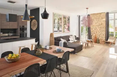 a kitchen and living room with a table and chairs at Super Central, Spacious, Sunny Large Deck & SPA in Cannes