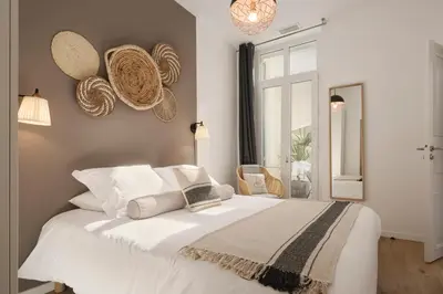 a bedroom with a white bed with hats on the wall at Super Central, Spacious, Sunny Large Deck & SPA in Cannes