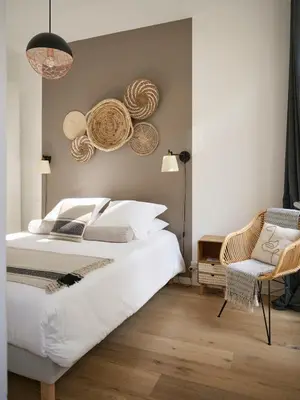 a bedroom with a large white bed and a chair at Super Central, Spacious, Sunny Large Deck & SPA in Cannes