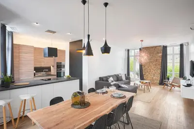a kitchen and living room with a wooden table and chairs at Super Central, Spacious, Sunny Large Deck & SPA in Cannes