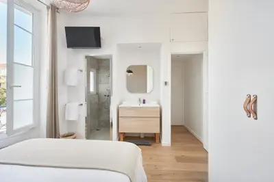 a white bedroom with a sink and a mirror at Super Central, Spacious, Sunny Large Deck & SPA in Cannes