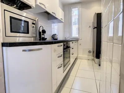a kitchen with white cabinets and a microwave at Quality 1 bedroom rue du Canada 5 mins Croisette 208 in Cannes