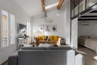 a living room with a couch and a bed at Loft Meynadier by Halldis in Cannes