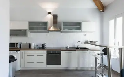 a kitchen with white cabinets and a stove top oven at Loft Meynadier by Halldis in Cannes