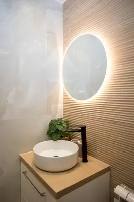 a bathroom with a sink and a round mirror at Jungle Room Jacuzzi Privé Évasion en amoureux in Cannes