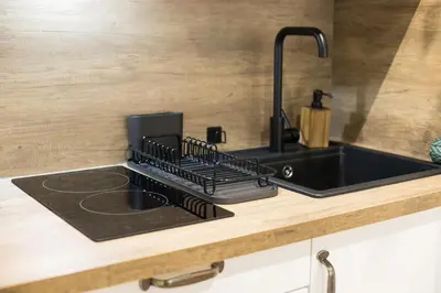a kitchen counter with a black sink and a counter top at Jungle Room Jacuzzi Privé Évasion en amoureux in Cannes