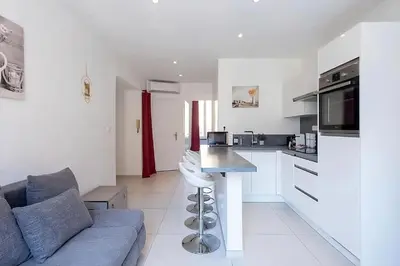 a living room with a couch and a kitchen at Nice 2 Rooms in the heart of Cannes in Cannes