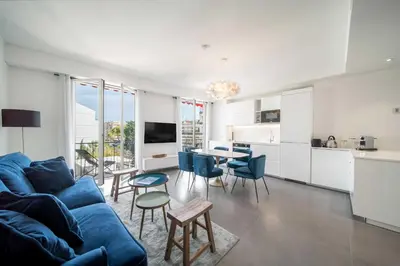 a living room with a blue couch and a kitchen at Superb 55m2 apartment - Heart of Cannes - 2BR4p in Cannes