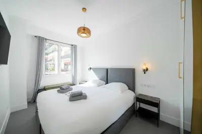 a bedroom with a large white bed and a window at Superb 55m2 apartment - Heart of Cannes - 2BR4p in Cannes