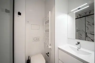 a white bathroom with a sink and a toilet at Superb 55m2 apartment - Heart of Cannes - 2BR4p in Cannes