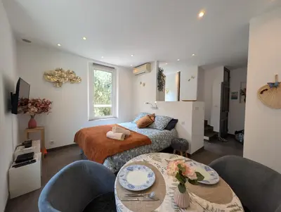 a bedroom with a bed and a table and chairs at Appartement - Cannes vieille ville - Le Suquet in Cannes