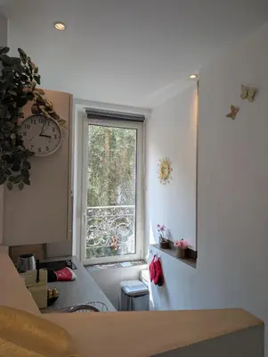 a kitchen with a window and a clock on the wall at Appartement - Cannes vieille ville - Le Suquet in Cannes