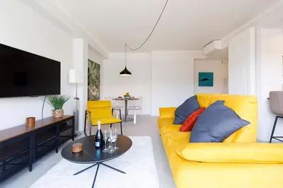 a living room with a yellow couch and a table at Wam YourHostHelper in Cannes