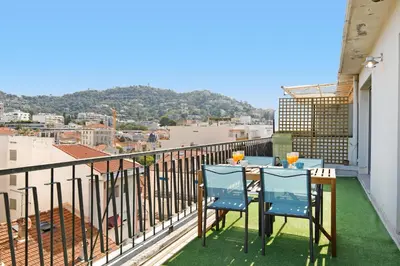 a balcony with two chairs and a table with a view at Wam YourHostHelper in Cannes