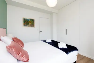 a white bedroom with a white bed and pillows at Wam YourHostHelper in Cannes
