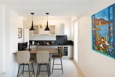 a kitchen with a table and chairs in a room at Wam YourHostHelper in Cannes