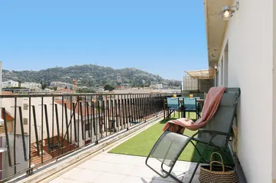 a balcony with a chair and a table on it at Wam YourHostHelper in Cannes