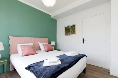 a bedroom with a large bed with pink and blue walls at Wam YourHostHelper in Cannes