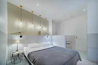 a bedroom with a large bed and two tables at Joli Studio TERRASSE, Venizelos-CANNES CENTRE A0B169 in Cannes