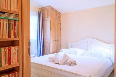 a bedroom with a large white bed and a window at Villa Cynthia - Piscine - Plage (à 50m) - Palais Congrès - Calme absolu in Cannes