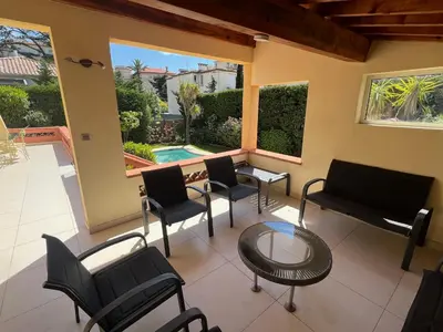 a living room with chairs and a table and a pool at Villa Cynthia - Piscine - Plage (à 50m) - Palais Congrès - Calme absolu in Cannes