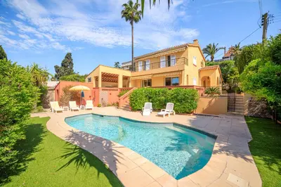 a kitchen with white appliances and a living room at Villa Cynthia - Piscine - Plage (à 50m) - Palais Congrès - Calme absolu in Cannes