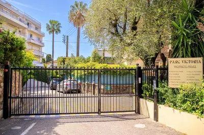 a living room with black leather couches and a television at Villa Cynthia - Piscine - Plage (à 50m) - Palais Congrès - Calme absolu in Cannes