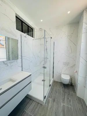 a white bathroom with a shower and a toilet at cote sud deux chambres proche croisette in Cannes