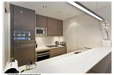 a kitchen with white countertops and a stainless steel refrigerator at REF 761 - Cannes Croisette - Sea view apartment for rent in Cannes