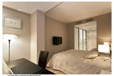 a bedroom with a bed and a table and a tv at REF 761 - Cannes Croisette - Sea view apartment for rent in Cannes
